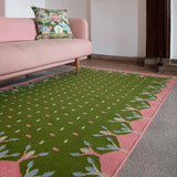 Living room with pink sofa and green and pink flatweave rug.