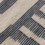 Detail of Indigo blue Tudor rug handwoven in natural tones of ecru, off-white and indigo blue with an organic textural graphic design.