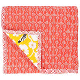Reversible, the back of the yellow weaver baby quilt is a coral red floral motif.