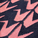 Detail of handwoven dark blue and pink flatweave wool rug