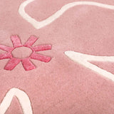 Detail of blush pink Hibiscus rug with floral motif