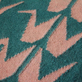 Detail of green and pink flatweave rug handwoven with Crane motifs from NZ wool