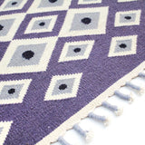 Detail of handwoven Lavender Evil Eye Flatweave wool rug with tassel edge