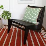 Rust Red Orange Darjeeling Stripe Rug with chair and cushion.