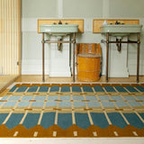 Corbie blue and ochre flatweave rug with grid design styled with antique furniture in a colourful interior.
