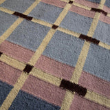 Close-up of Pigeon Blue Corbie flatweave wool rug showing geometric pattern detail.