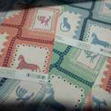 Close-up of Folk Tales wallpaper samples in pink, blue and green with illustrated animal pattern.