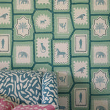 Folk Tales wallpaper in pistachio green with illustrated animal pattern shown in a lifestyle setting.